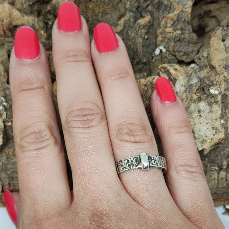 Anillos de boda de dos tonos, uno dorado y otro plateado, sobre un fondo suave.